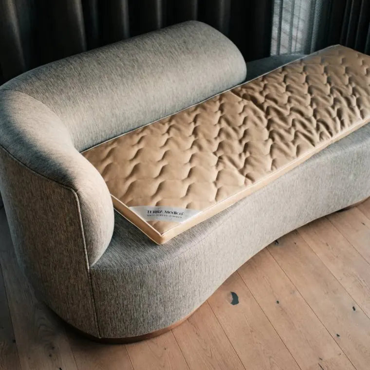 Das BETTER³ Regenerationssystem liegt als Auflage auf einem Sofa